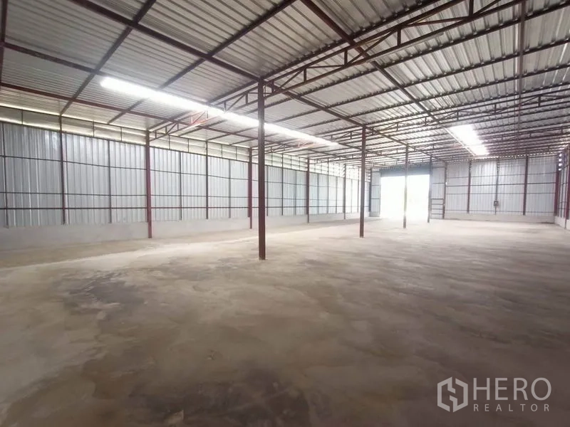 货栈 出租在Mueang Samut Sakhon, Samut Sakhon - 仓库内部空间开阔，钢柱结构、挑高屋顶，带采光板与混凝土地面。