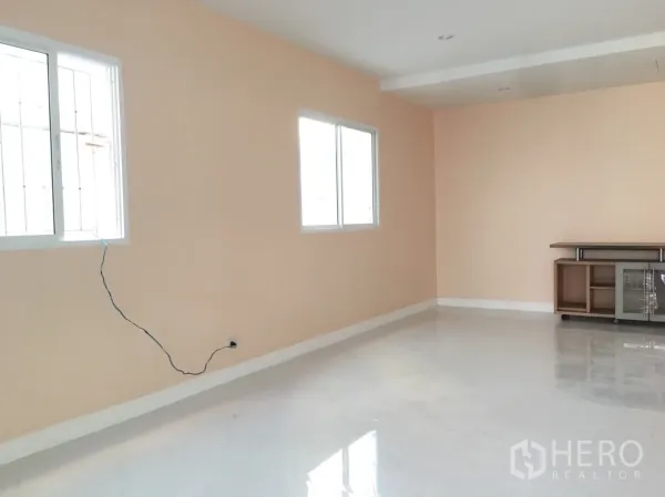 联排别墅 出租在Huai Khwang, Bangkok - 明亮客厅，米桃色墙面与白色亮面地砖，双窗采光。