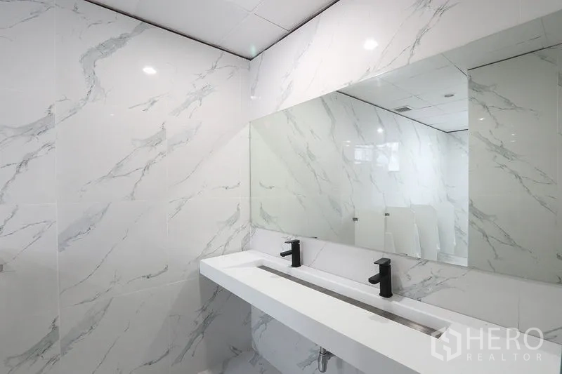 办公空间 出租在Bang Na, Bangkok - 翻新卫浴，仿大理石墙面，长槽式台盆与黑色龙头。