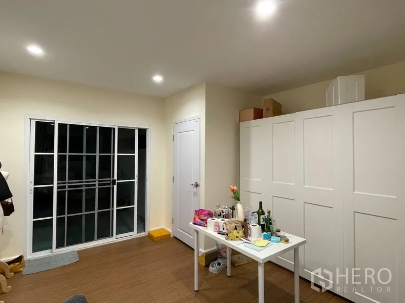 ทาวน์เฮาส์ ให้เช่าในPhra Khanong, Bangkok - ห้องกว้างพร้อมตู้เสื้อผ้าบานใหญ่สีขาว และประตูกระจกบานเลื่อนไปยังระเบียง