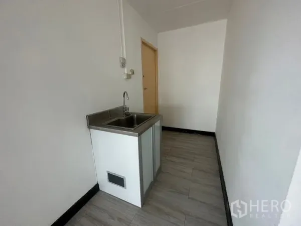 办公空间 出租或出售 - 白色墙面与木纹地板的茶水区，配不锈钢水槽。