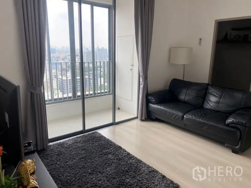 公寓 出售在Phra Khanong, Bangkok - 通过高挑推拉门通向阳台，面向曼谷天际线