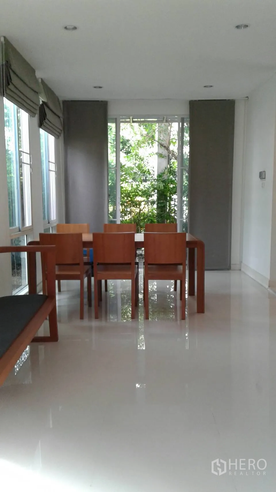 Townhouse for rent or sale in Suan Luang, Bangkok - Spacious dining area with floor-to-ceiling windows overlooking trees.