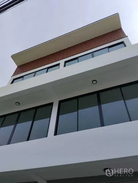 Home Office for sale - Close-up of the upper levels showing minimalist lines, deep eaves, and expansive glazing.