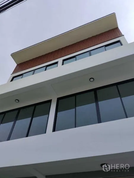 Home Office for sale - Close-up of the upper levels showing minimalist lines, deep eaves, and expansive glazing.