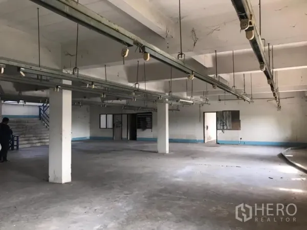 货栈 出租在Bueng Kum, Bangkok - 宽敞生产区，悬挂机轨贯穿，混凝土地面与立柱，侧边办公室与楼梯。