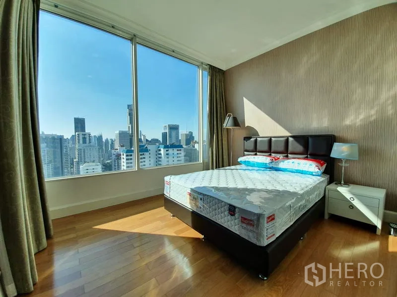 公寓 出租在Watthana, Bangkok - 转角卧室，宽幅城市视野，床头柜与温润木地板。