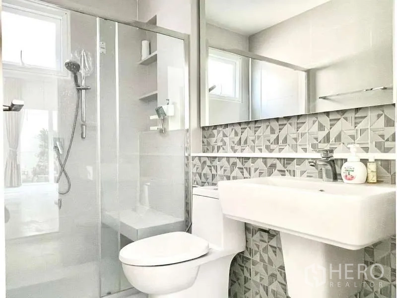 บ้าน ให้เช่าในPrawet, Bangkok - ห้องน้ำที่สองลายผนังโมเสก มีตู้กระจกอาบน้ำและหน้าต่างระบายอากาศ.