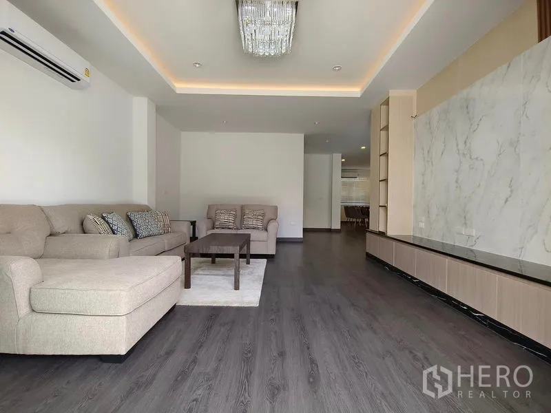 Detached House for rent or sale - Elegant living room with chandelier, sofa set, and long TV console.