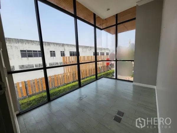 Office Space for rent in Yan Nawa, Bangkok - Corner office with floor-to-ceiling glass, light wood floors and courtyard view.