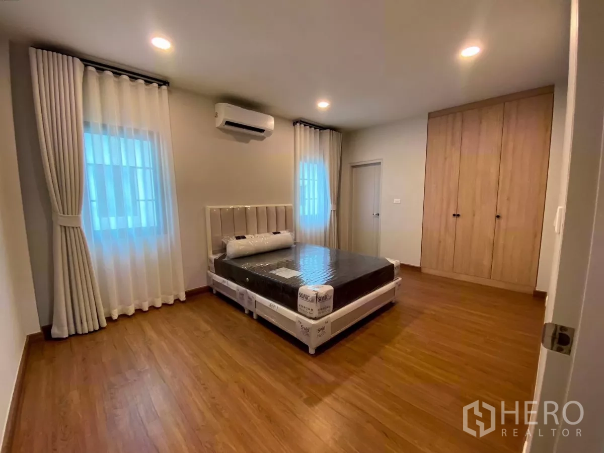 Detached House for rent in Bang Phli, Samut Prakan - Guest bedroom with built-in wardrobe, windows on two sides and air conditioning.
