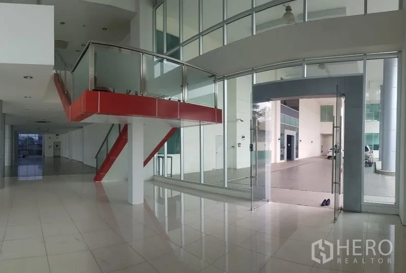 Retail Space for rent in Prawet, Bangkok - Double-height lobby with a red feature staircase and full glass entrance doors.