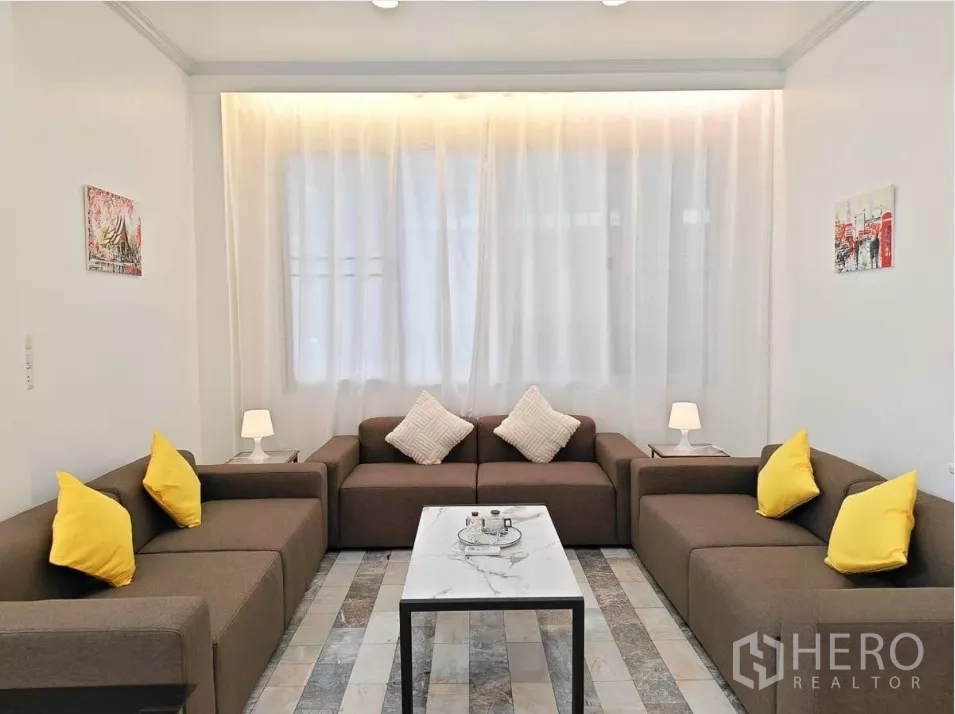 บ้าน ให้เช่าในYan Nawa, Bangkok - มุมนั่งเล่นอบอุ่น โซฟาแบบตัวยู โต๊ะกลางหินอ่อน และผ้าม่านโปร่ง