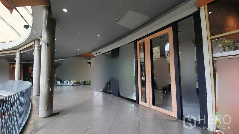 零售空间 出租在Khlong Toei, Bangkok - 玻璃与木门店面沿阳台式走道延伸