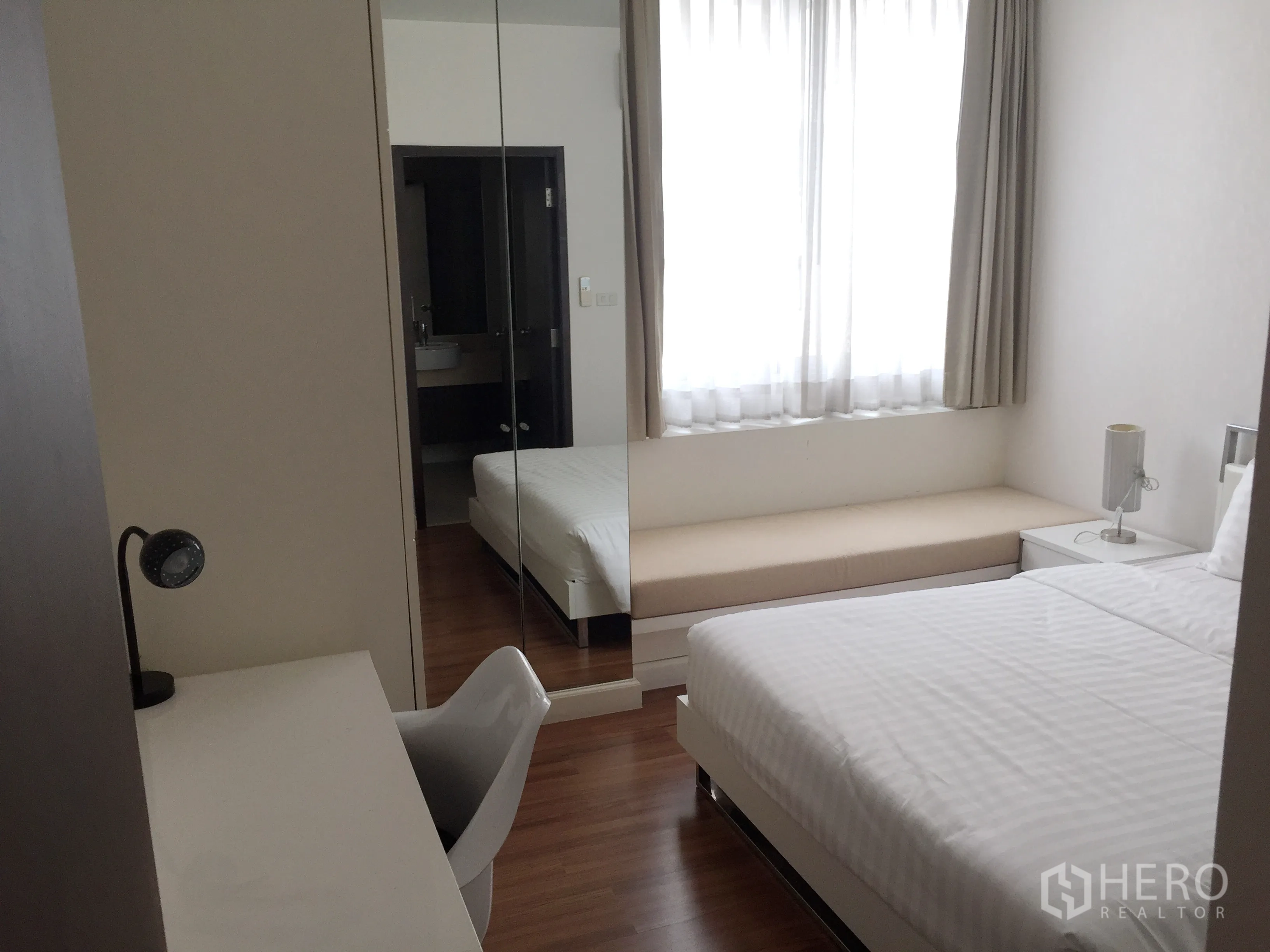 คอนโด ให้เช่าในPathum Wan, Bangkok - ห้องนอนรองพร้อมเตียง โต๊ะทำงาน ตู้เสื้อผ้าบานกระจก และหน้าต่างบานใหญ่มีเบาะนั่ง