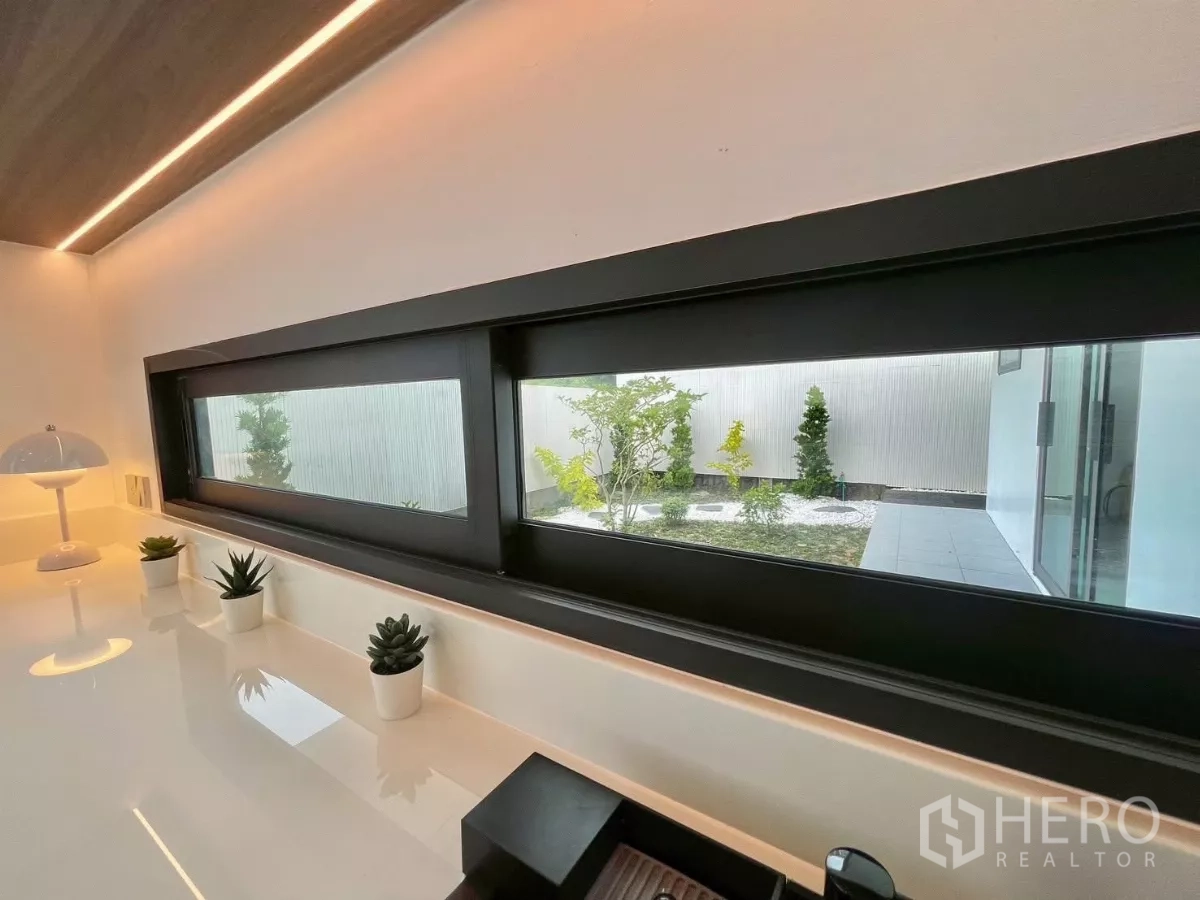 独立式住宅 出售在Prawet, Bangkok - 厨房长条横窗，眺望极简风庭院与碎石景观。