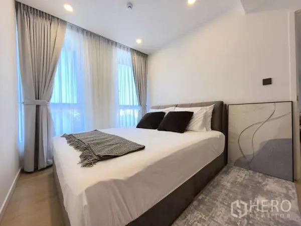 อพาร์ทเมนท์ ให้เช่า - ห้องนอนอบอุ่น เตียงคู่ หน้าต่างเต็มบานและผ้าม่านทึบสีเทา