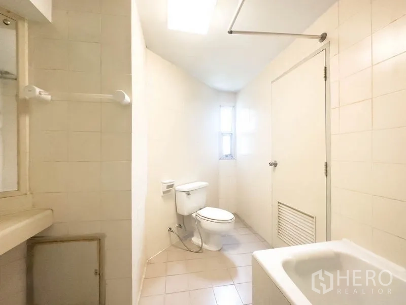 คอนโด ขายในBang Na, Bangkok - ห้องน้ำสว่างมีอ่างอาบน้ำ โถสุขภัณฑ์ และหน้าต่างบานเล็ก.