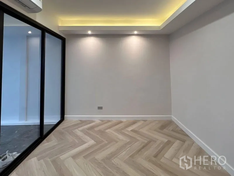 ทาวน์เฮาส์ ให้เช่าหรือขาย - ห้องเอนกประสงค์โล่ง พื้นลายก้างปลา ไฟซ่อนฝ้า และผนังกระจก