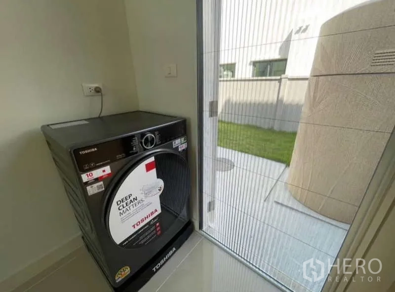 Detached House for rent in Bang Phli, Samut Prakan - Laundry corner with Toshiba washing machine and door to the backyard.