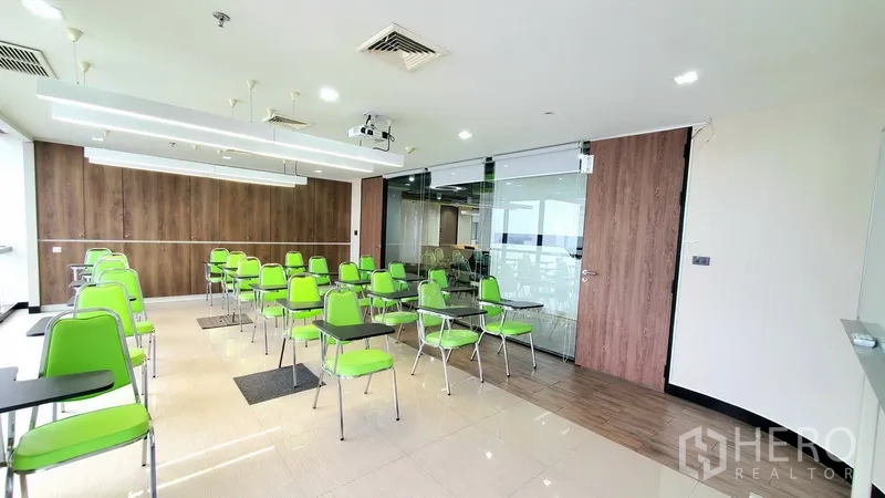 办公空间 出租在Watthana, Bangkok - 明亮的研讨室，绿色座椅、投影设备、推拉玻璃门与木饰面。