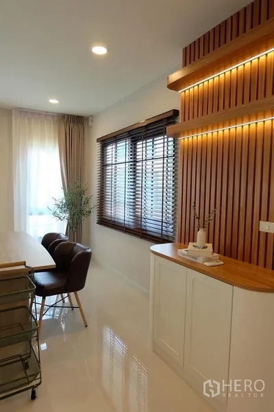 Detached House for rent in Bang Phli, Samut Prakan - Dining nook with window blinds, LED-lit wood slat wall and storage cabinet.