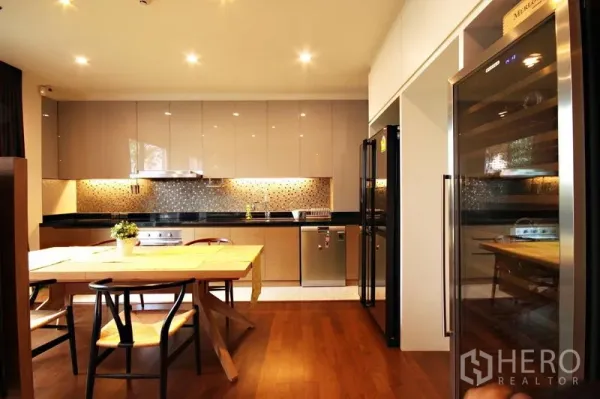 คอนโด ให้เช่าหรือขายในKhlong Toei, Bangkok - ครัวและส่วนทานอาหารหันเข้าหาตู้เย็นคู่และตู้แช่ไวน์ โทนไม้อบอุ่น