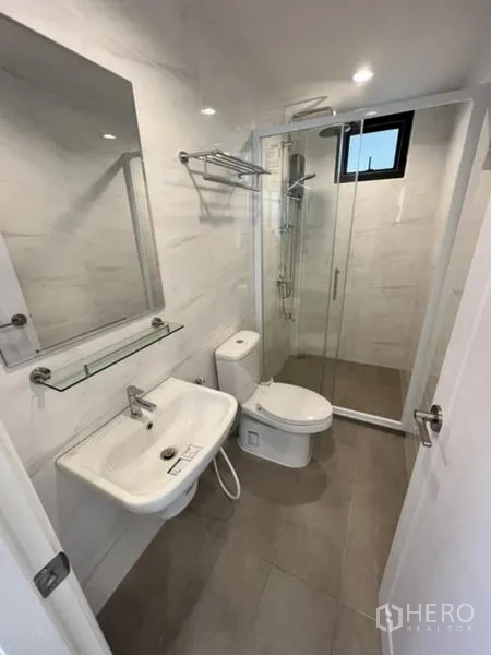 独立式住宅 出租在Phaya Thai, Bangkok - 小巧卫浴，半无框玻璃淋浴与壁挂洗手台。