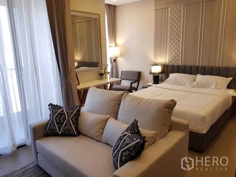 คอนโด ให้เช่าในWatthana, Bangkok - โซฟาหน้าเตียง ผ้าม่านสูงจรดเพดาน และประตูสู่ระเบียงขนาดกะทัดรัด