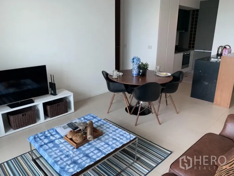 公寓 出租或出售在Khlong San, Bangkok - 曼谷公寓的开放式客厅，带电视柜、圆形餐桌和现代厨房。