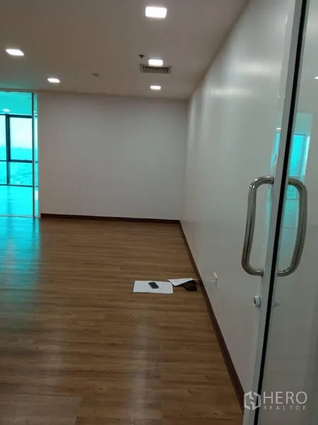 办公空间 出租在Huai Khwang, Bangkok - 办公走廊带玻璃门与不锈钢把手，嵌灯与木地板通向开放式区域。