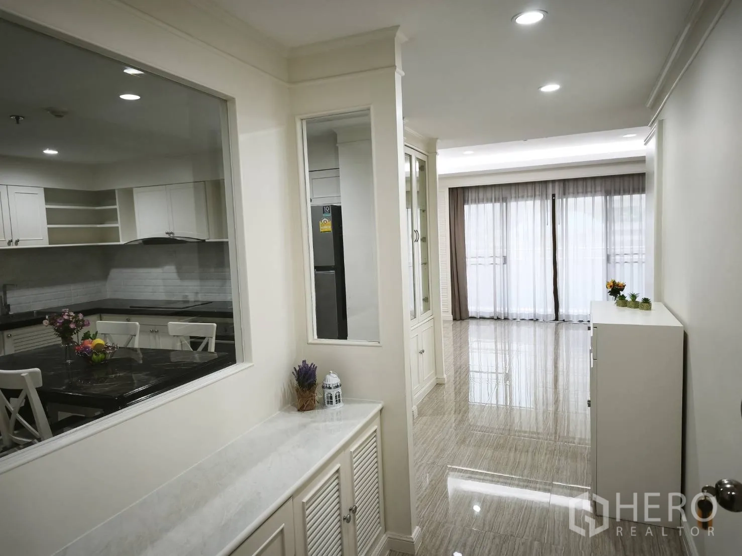 Condominium for rent in Watthana, Bangkok - Bright entry hall with built-in cabinetry, glass partition to the kitchen, and sliding doors to a balcony.