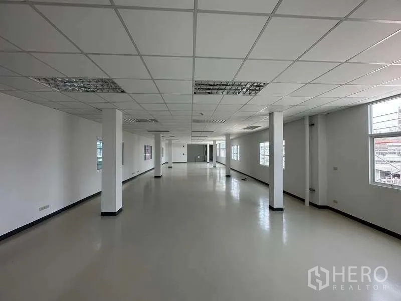 Factory for rent in Khlong Luang, Pathum Thani - Bright open-plan office area with grid ceiling, columns and windows.