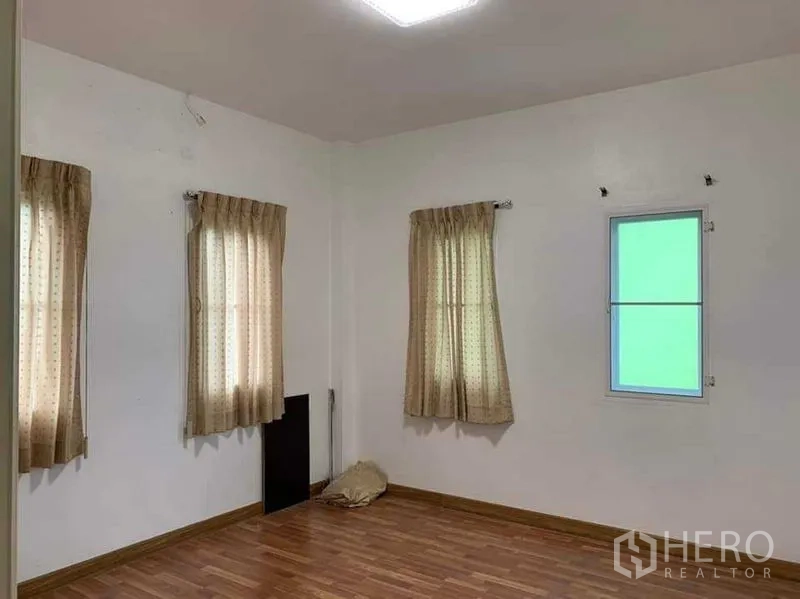 บ้าน ขายในSai Mai, Bangkok - ห้องนอนโล่ง พื้นไม้ ผนังสีขาว มีหน้าต่างและผ้าม่าน