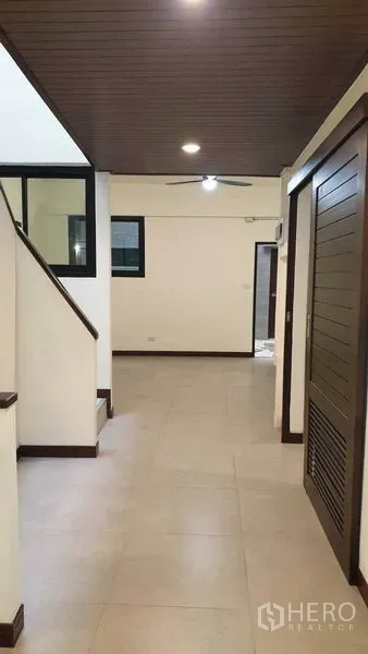 ทาวน์เฮาส์ ให้เช่าหรือขายในKhlong Toei, Bangkok - โถงทางเดินพร้อมบันไดและฝ้าไม้ เชื่อมสู่ชั้นบน