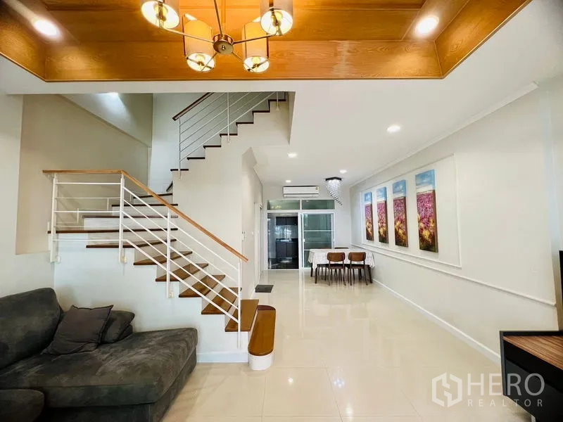 联排别墅 出租在Prawet, Bangkok - 开放式客餐厅，现代楼梯、吊灯与亮面地砖