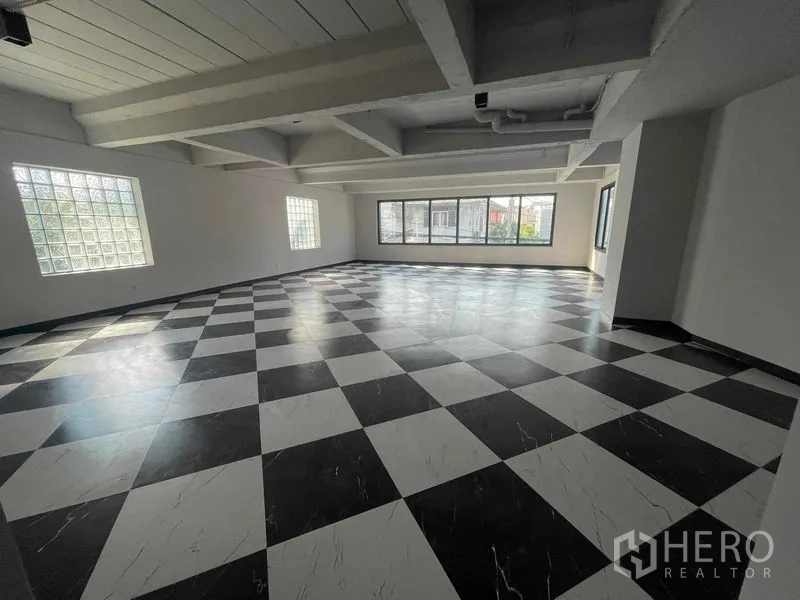 Home Office for rent in Phaya Thai, Bangkok - Top-floor space with black-and-white checkerboard tiles and wide windows bringing natural light.
