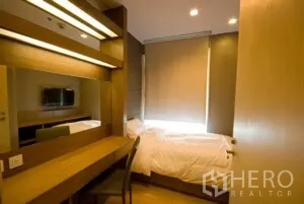 คอนโด ให้เช่าในKhlong Toei, Bangkok - ห้องนอนเล็กอบอุ่นพร้อมเตียงเดี่ยว โต๊ะทำงานบิลท์อินยาว กระจกบานใหญ่ และมู่ลี่ทึบแสง