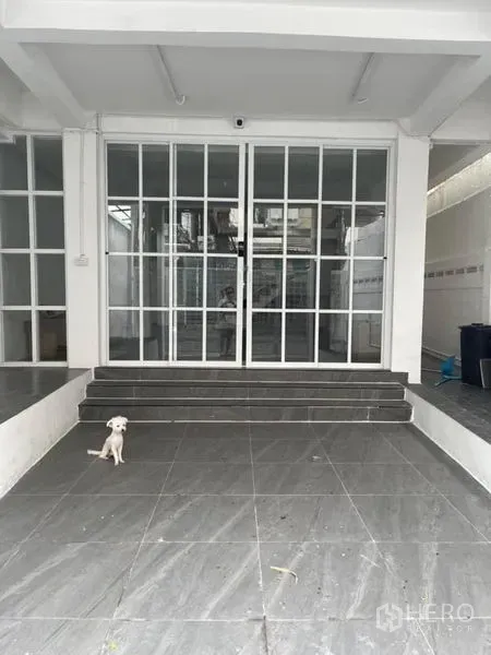 Townhouse for sale in Din Daeng, Bangkok - Covered carport with grey tiles and steps leading to wide glass sliding entrance doors.