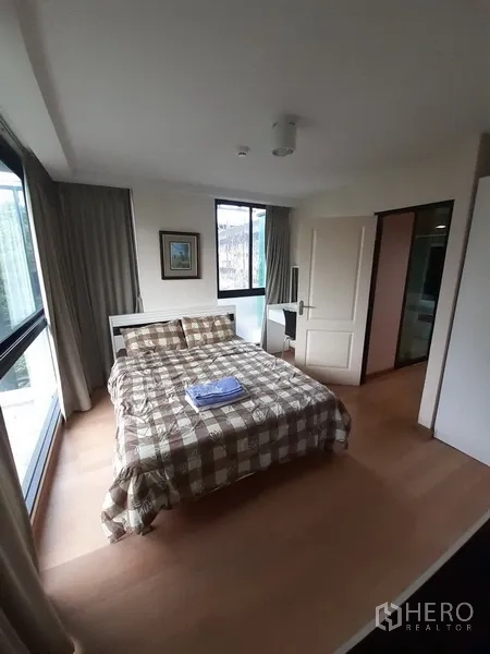 คอนโด ให้เช่าหรือขายในChatuchak, Bangkok - ห้องนอนมุมอาคาร หน้าต่างบานใหญ่สองด้าน เตียงคู่ และประตูห้องน้ำในตัว