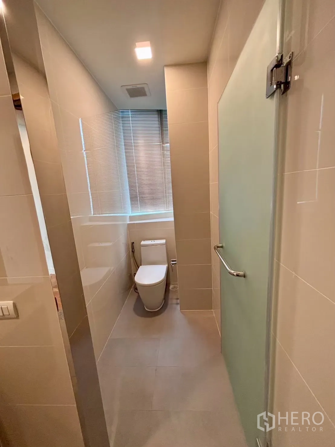 Condominium for rent in Khlong Toei, Bangkok - Bathroom corridor with toilet and frosted glass shower door