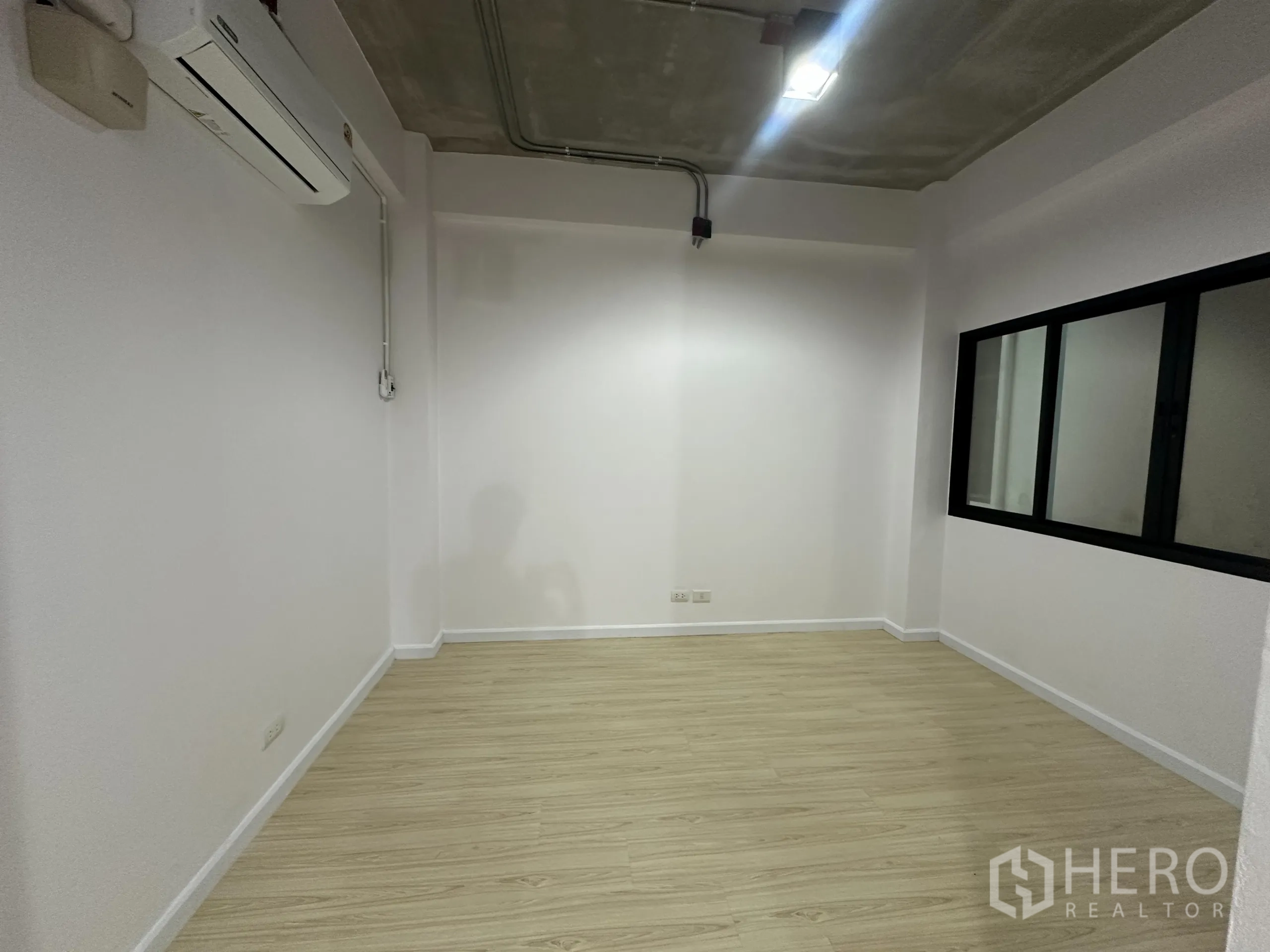 Office Space for rent in Watthana, Bangkok - Private meeting room with window, split-type air conditioner and wood-look flooring.