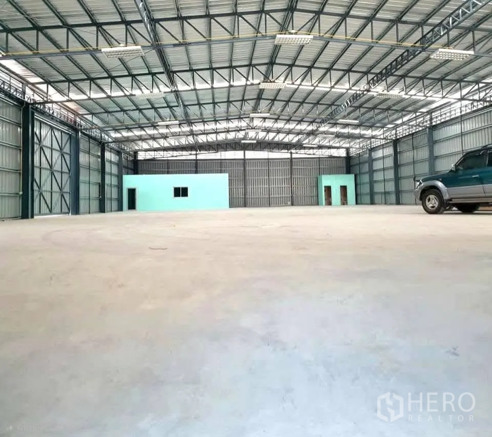 Warehouse for rent in Phaya Thai, Bangkok - Open warehouse floor with a column-free span, built-in rooms at the far end, and vehicle access.