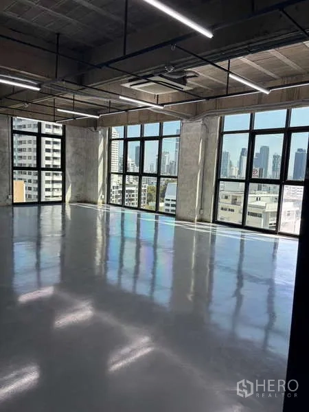 Office Space for rent - Sunlit corner office with floor-to-ceiling windows, polished floor and Bangkok skyline views.