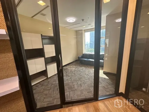 办公空间 出租 - 玻璃隔间的独立办公室，地毯地面，内置柜及靠窗沙发，可欣赏城市景观。