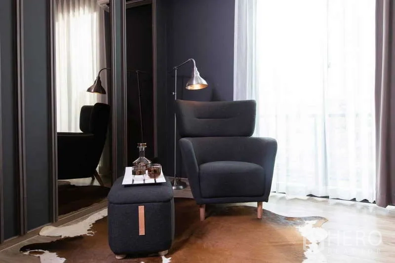 บ้าน ให้เช่าหรือขายในLat Krabang, Bangkok - มุมอ่านหนังสืออบอุ่น เก้าอี้เอนหลัง โคมไฟ และผนังสีเข้มข้างหน้าต่าง