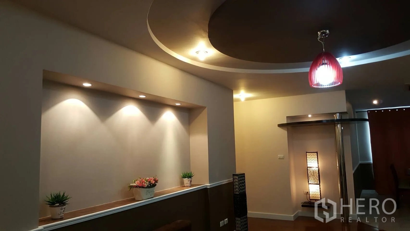 Condominium for rent in Khlong Toei, Bangkok - Close view of illuminated wall niche and modern pendant beneath a circular tray ceiling.