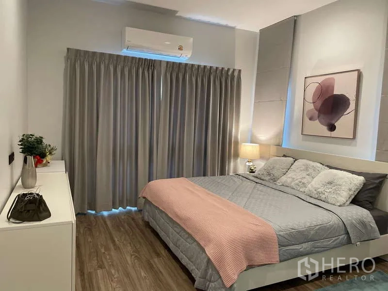 Detached House for rent in Bang Kapi, Bangkok - Secondary bedroom with king bed, grey curtains and wood flooring.