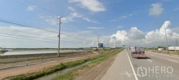 Land for sale in Mueang Samut Sakhon, Samut Sakhon - Highway 35 (Rama 2 Road) lanes with a truck passing by open salt ponds and power lines.