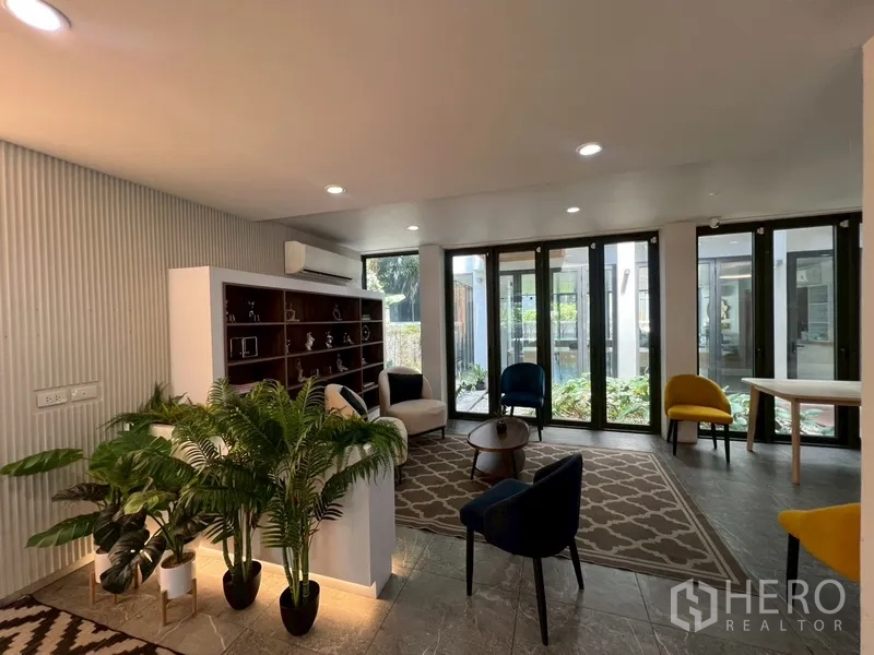 带办公室的家 出租或出售在Phra Khanong, Bangkok - 接待休闲区，内置书架，窗外花园景